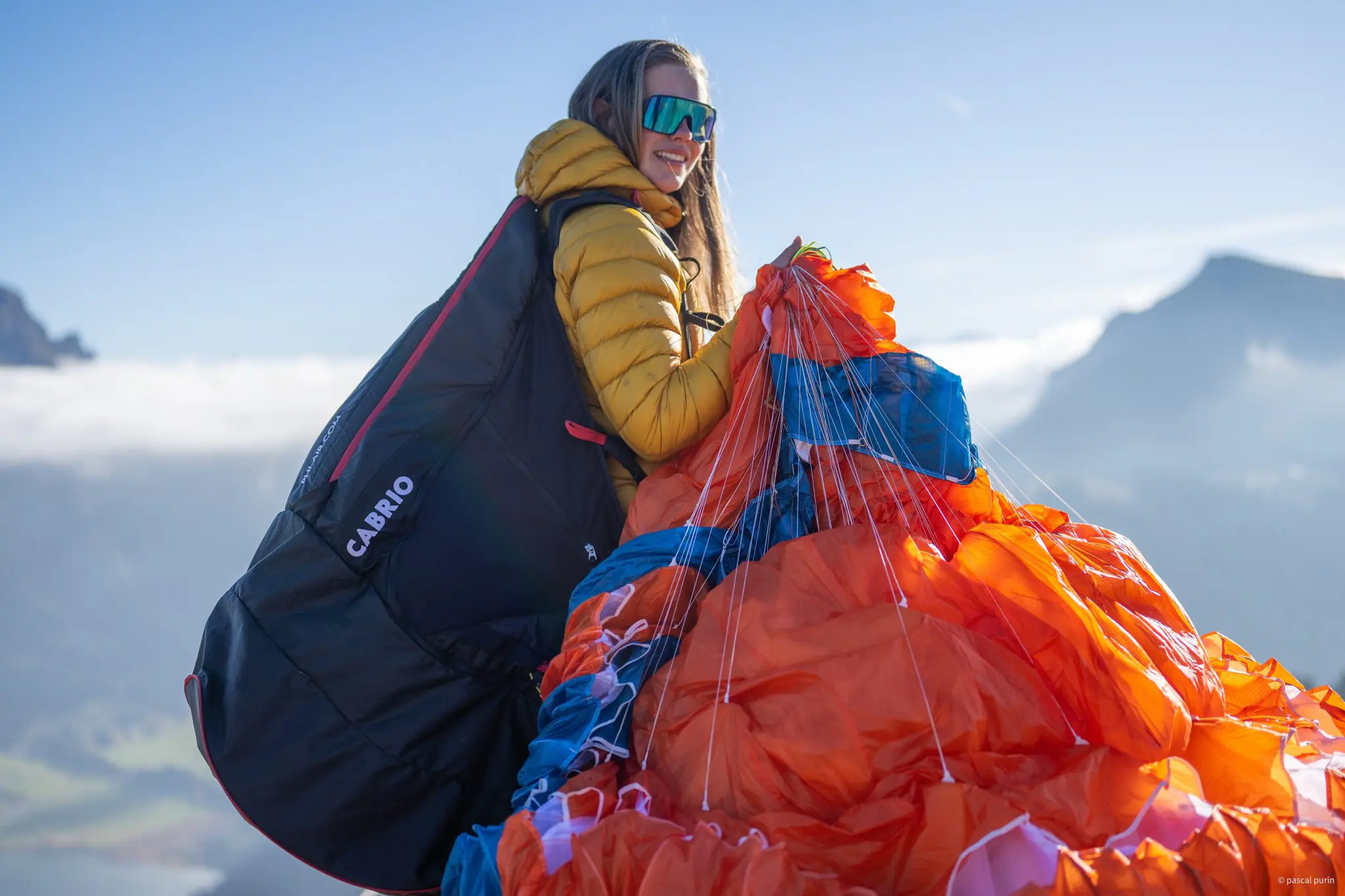 Paraglider pilot preparing for mountain takeoff