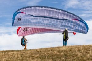 Pilote en vol avec une aile de parapente neuve — location flexible Locawing
